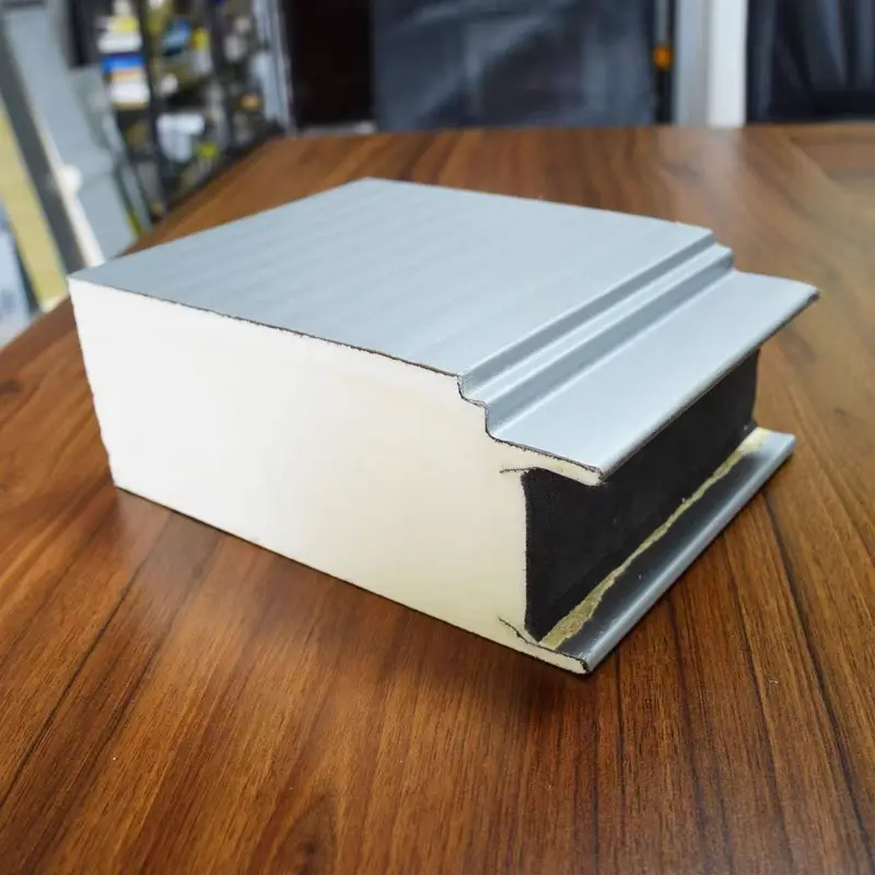 Stack of dark gray PU sandwich panels with reflective foil face — ready for shipping