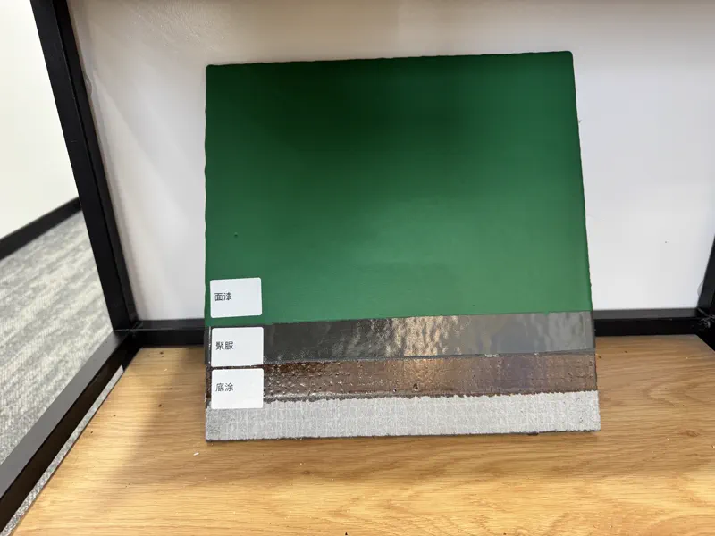 Polyurea sample — orange sand-textured coating